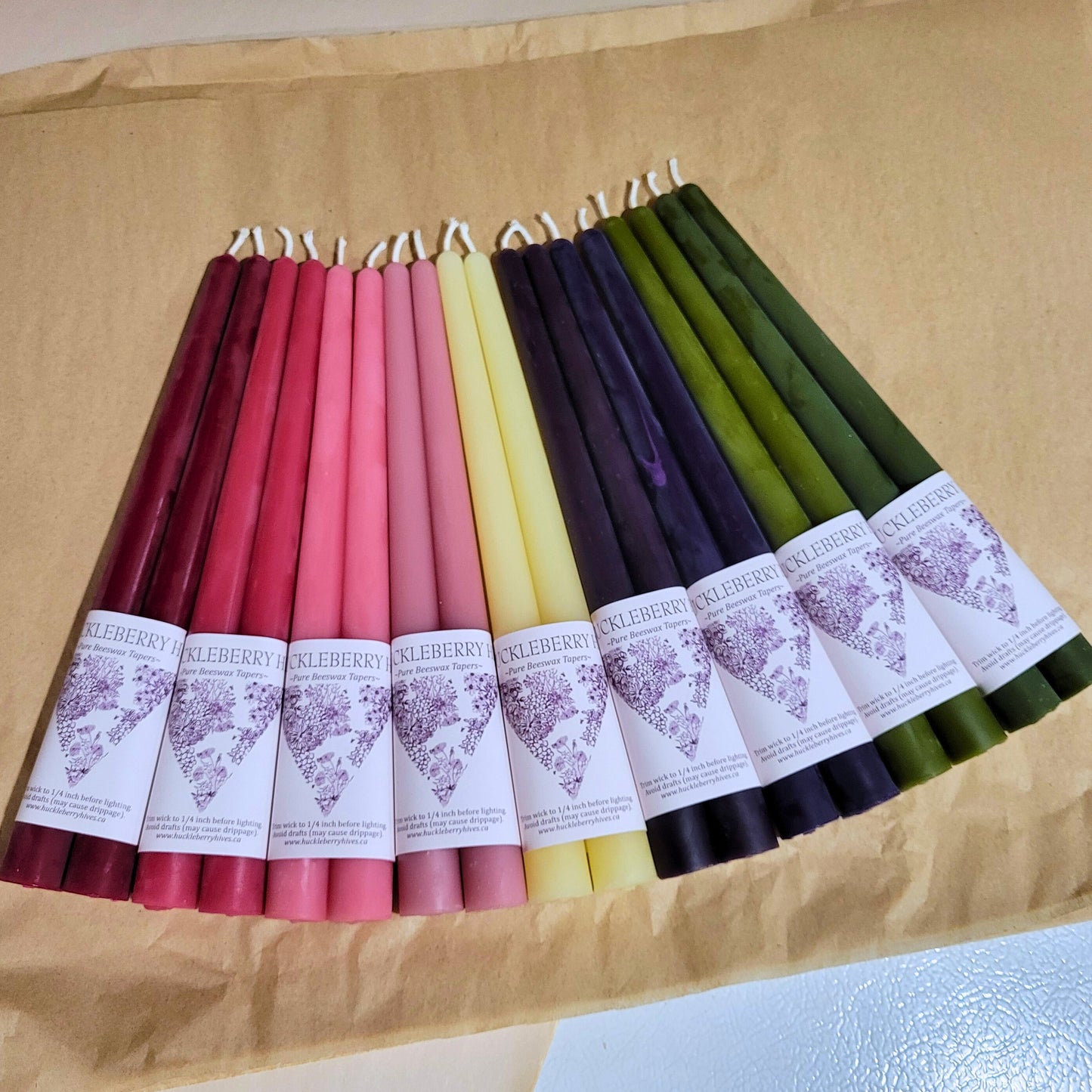 Colorful candles with labels on a brown surface