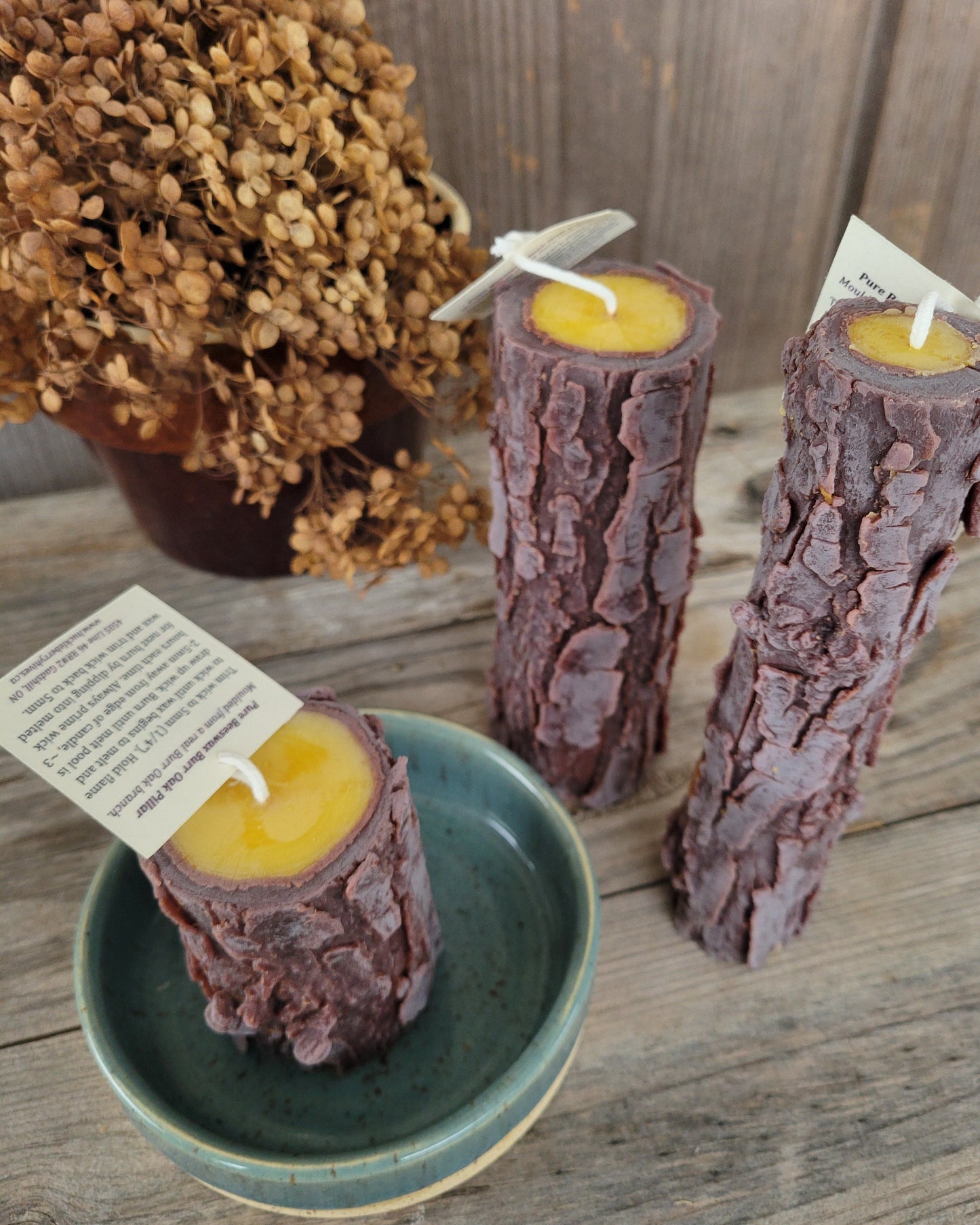 Candle logs with yellow centers on a wooden surface, some in a green bowl.