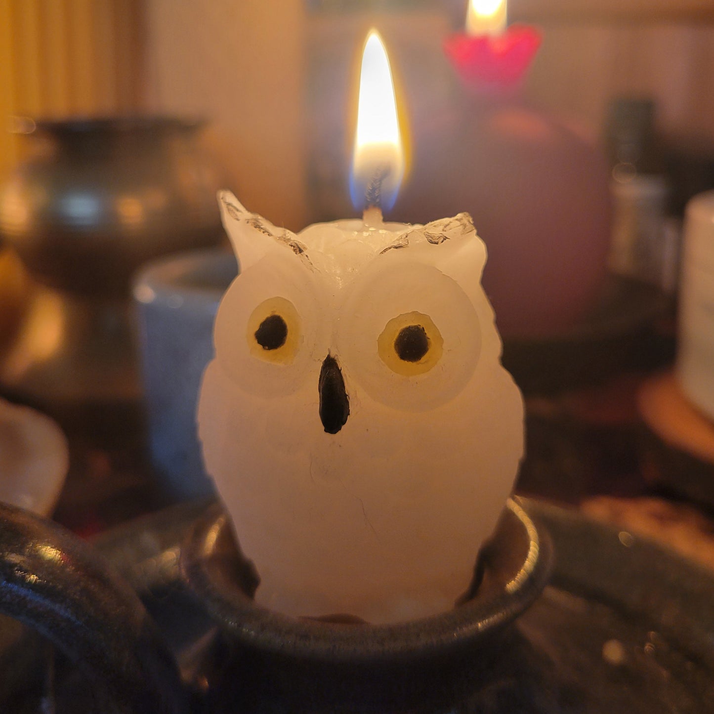 White owl-shaped candle with a blurred background