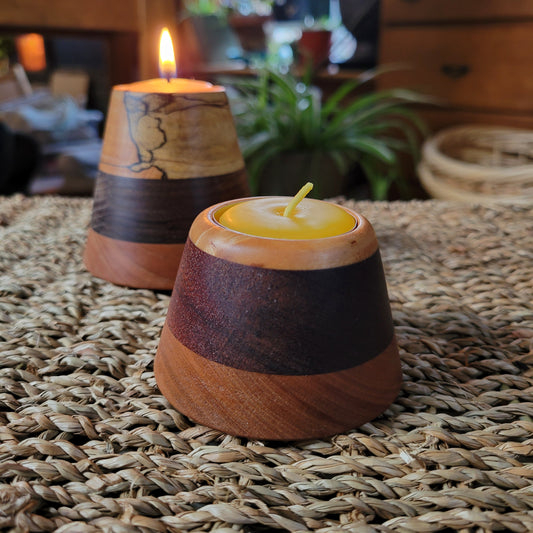 Wooden candle holder with a candle on a woven surface