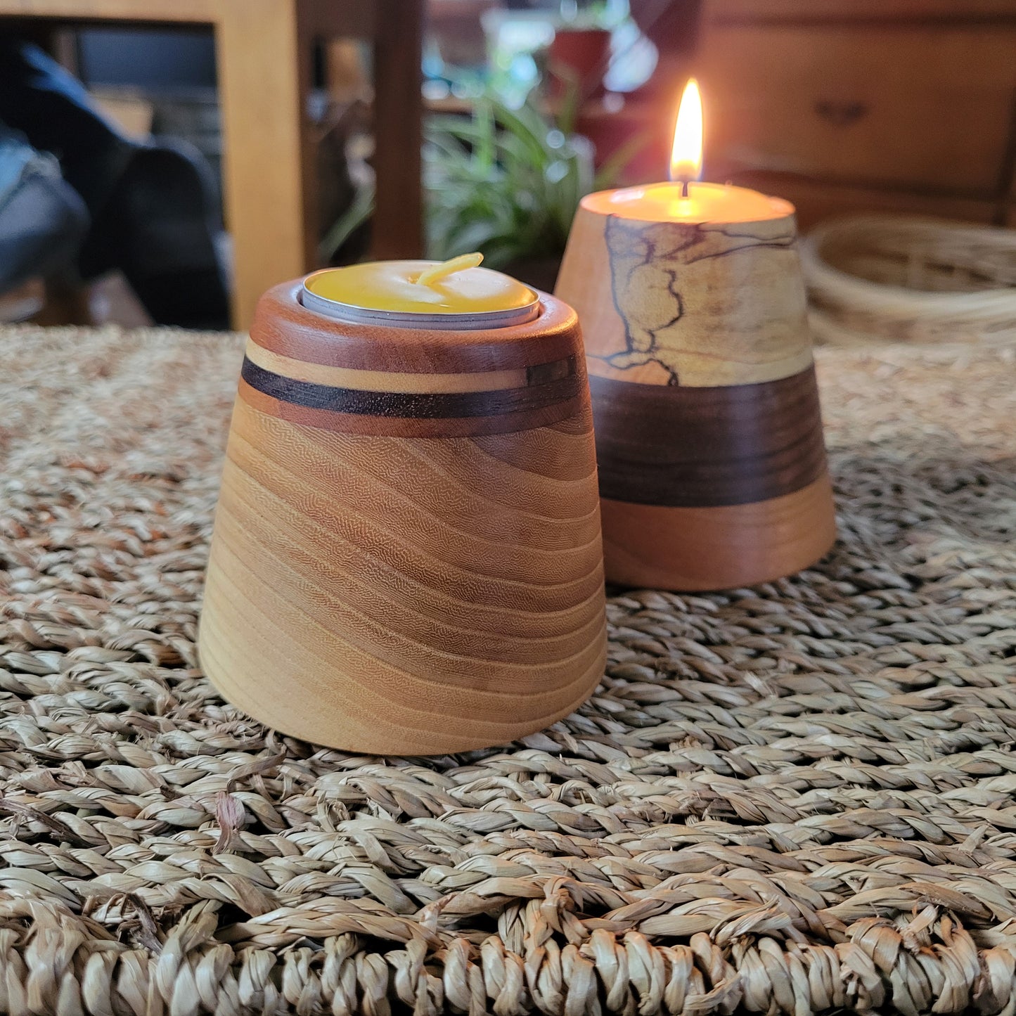 Wooden candle holders with candles on a textured surface