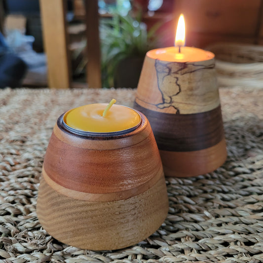 Wooden candle holders with lit candles on a textured surface