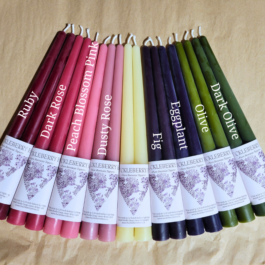 Row of colorful candles with labels on a beige background