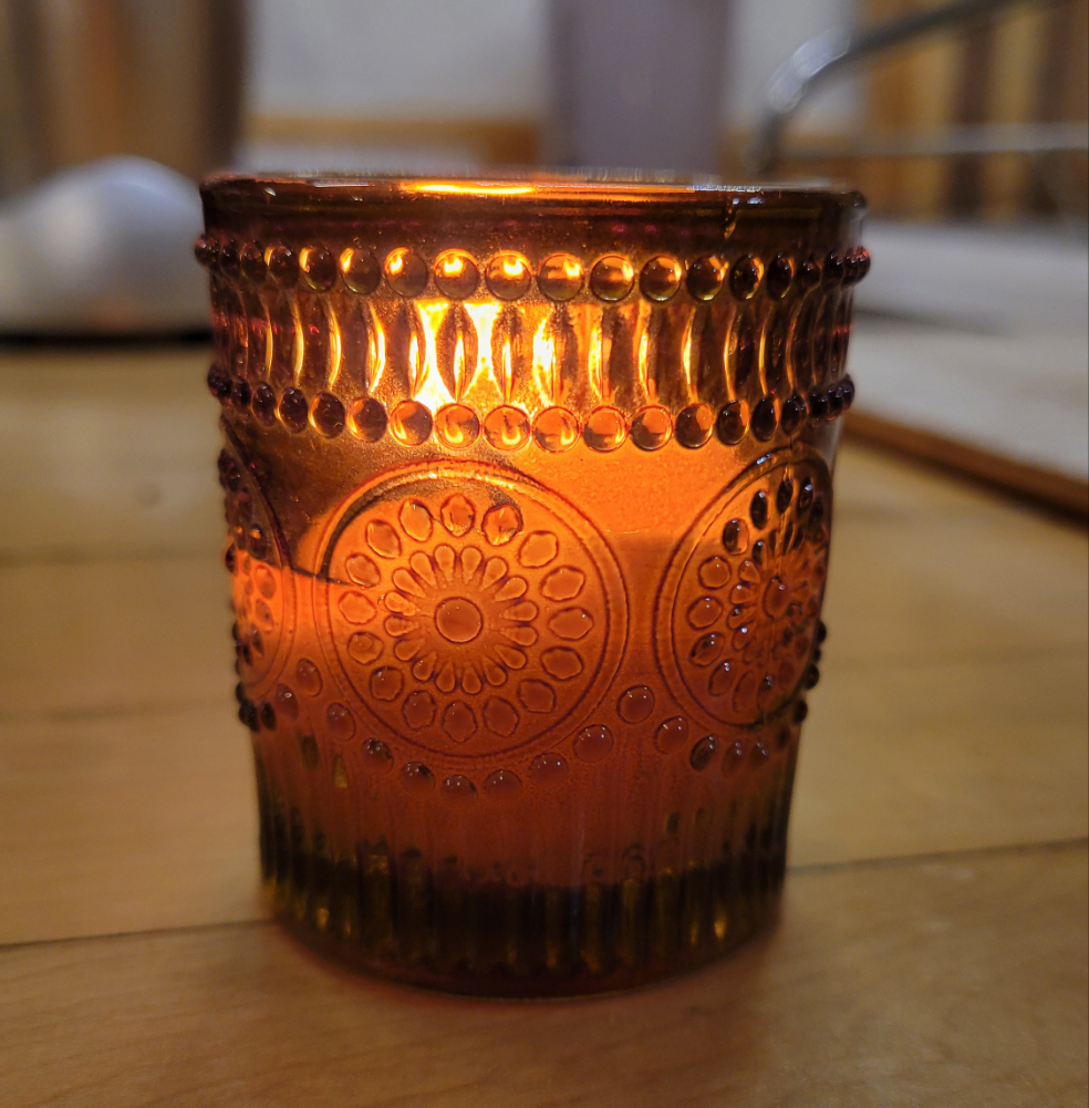 Amber glass candle burning.