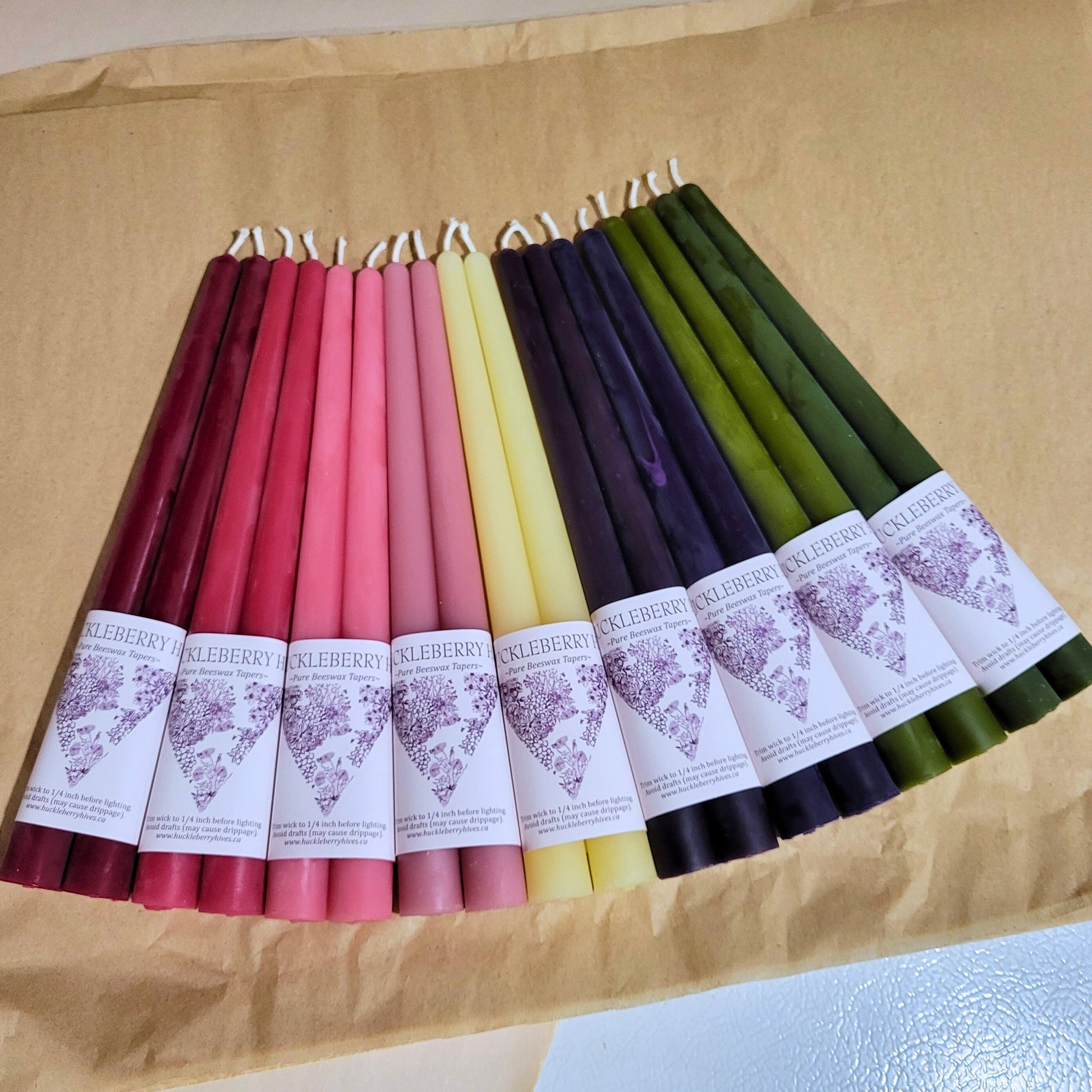 Colorful candles with labels on a brown surface