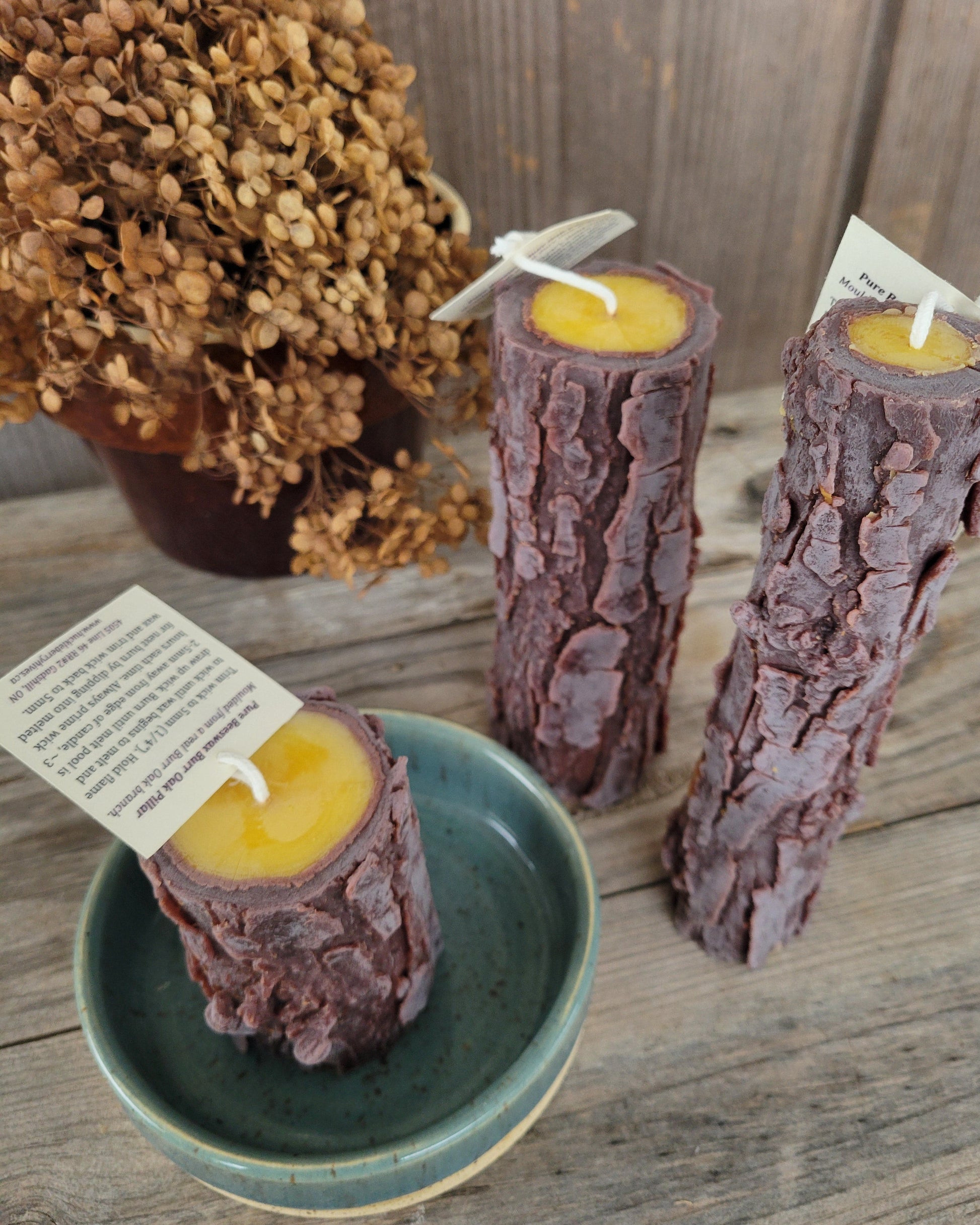 Candle logs with yellow centers on a wooden surface, some in a green bowl.