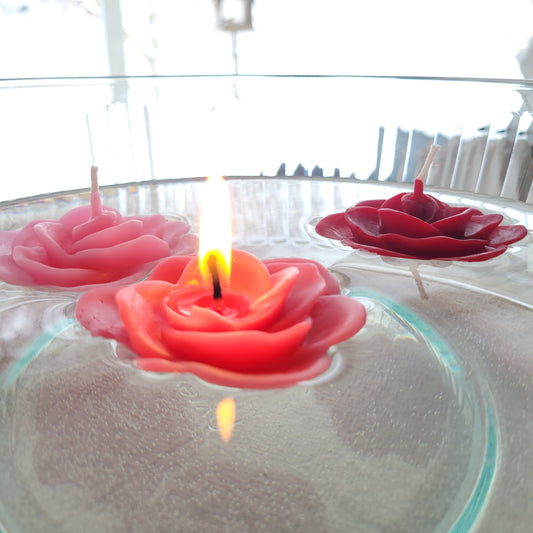 Rose-shaped floating candles in a bowl of water with a blurred background