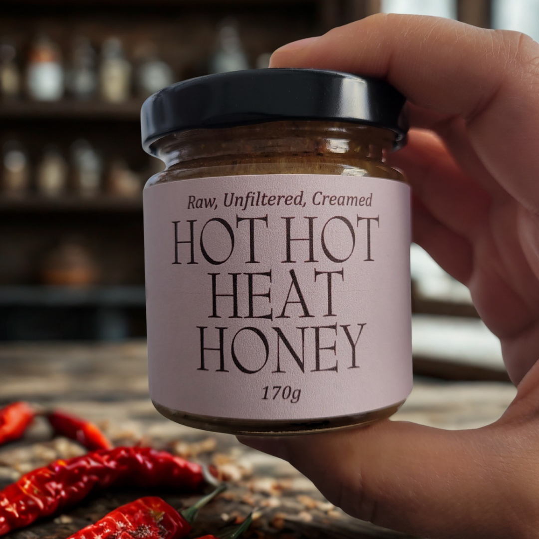 Hot Hot Heat Honey jar with peppers on the table beside it
