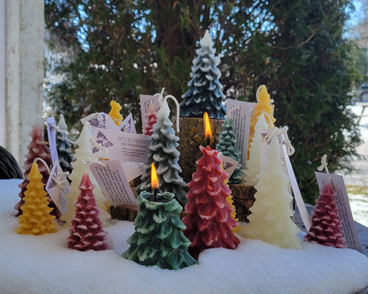 Colorful Christmas tree-shaped candles with a snowy background