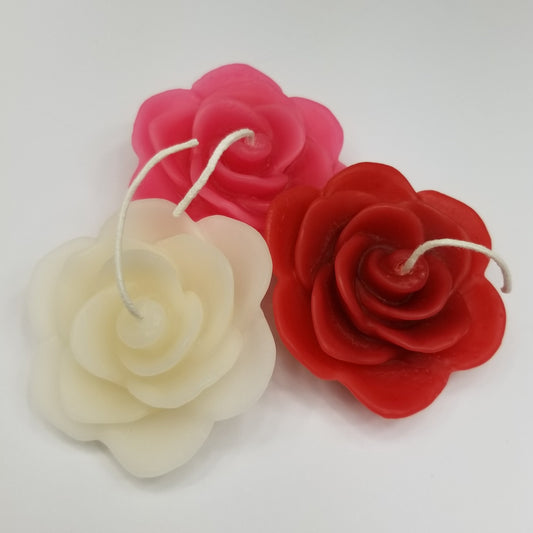 three rose candles, red, white and pink