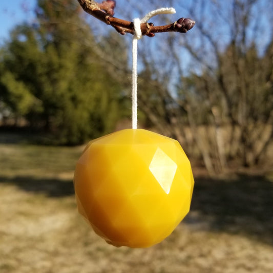geodesic sphere candle hanging from branch