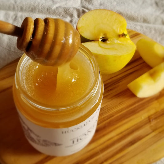 Honey dipper in jar of raw honey