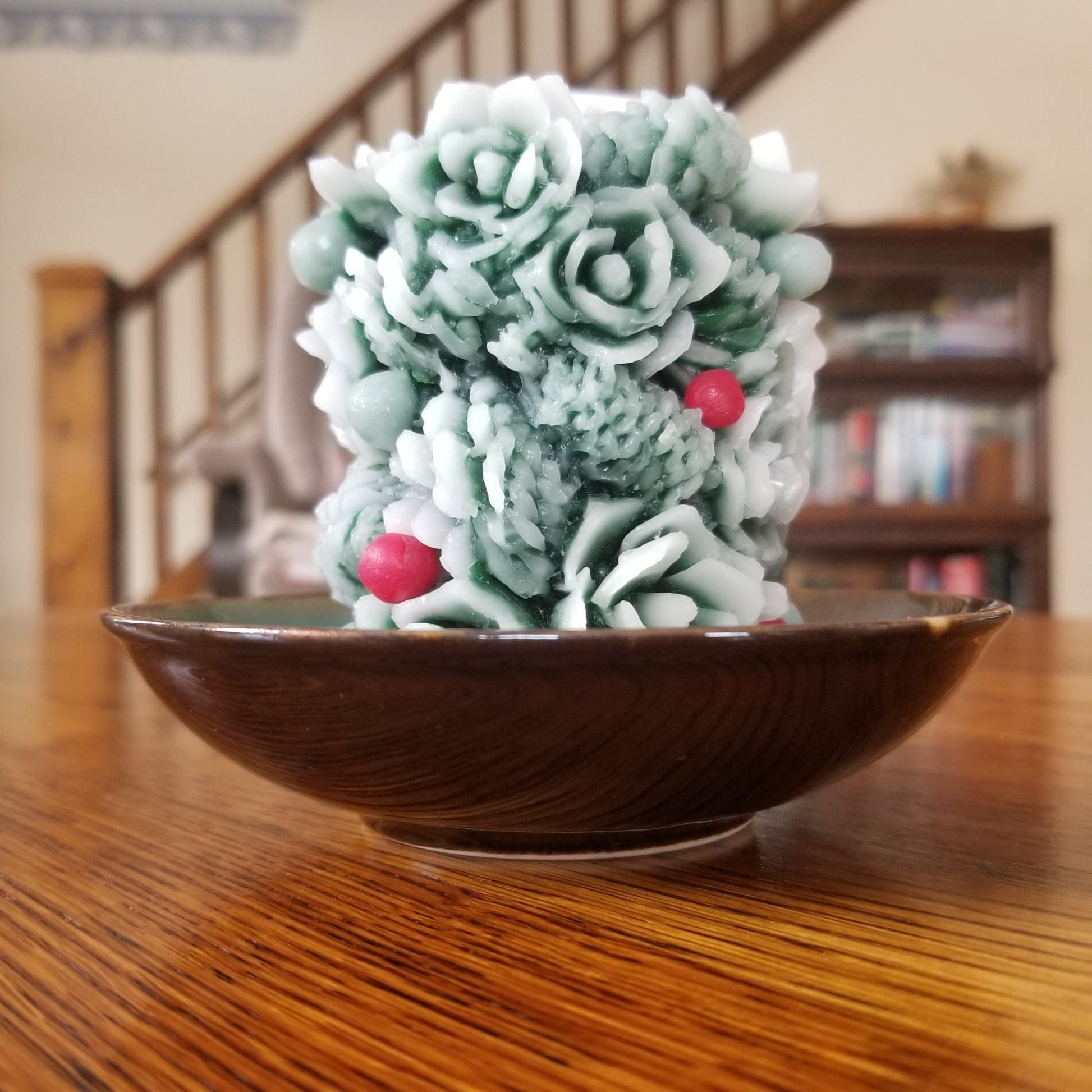 Beeswax greenery pillar; green with white frosting effect and red berries